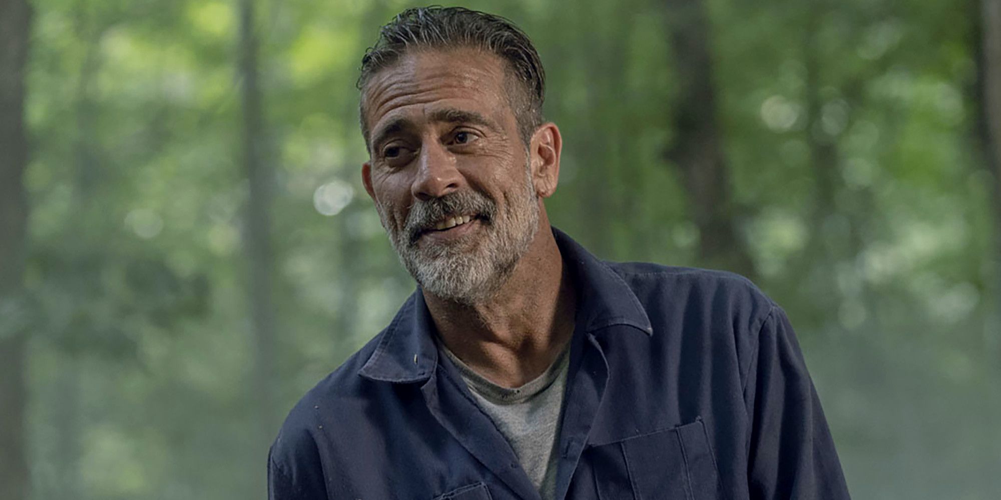 Negan laughing while looking to his right in The Walking Dead