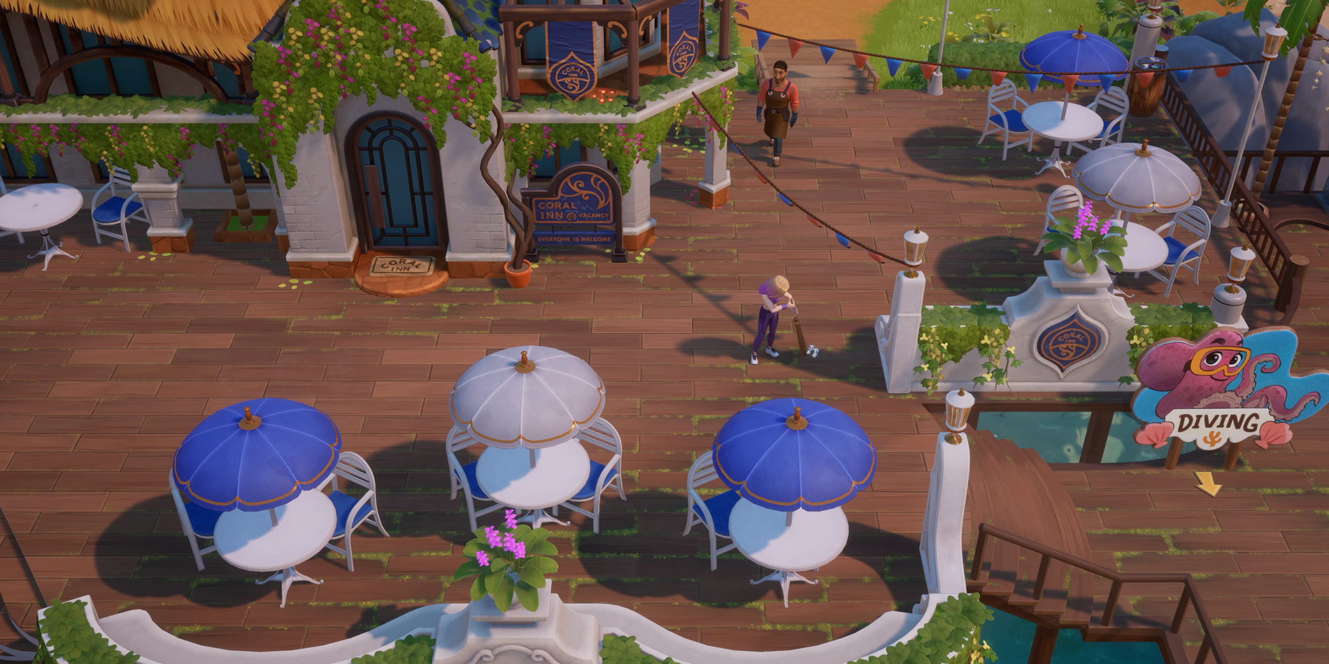 Looking at the outside front of the Coral Island Inn with tables and chairs set up and one of the twins sweeping and