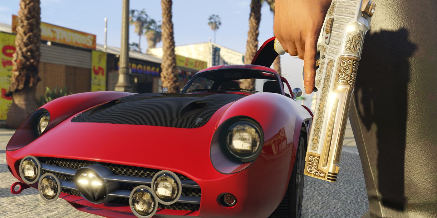 A red sports car with a black hood on Los Santos streets, with an unseen character holding an upgraded pistol with gold and silver detailing in GTA Online.