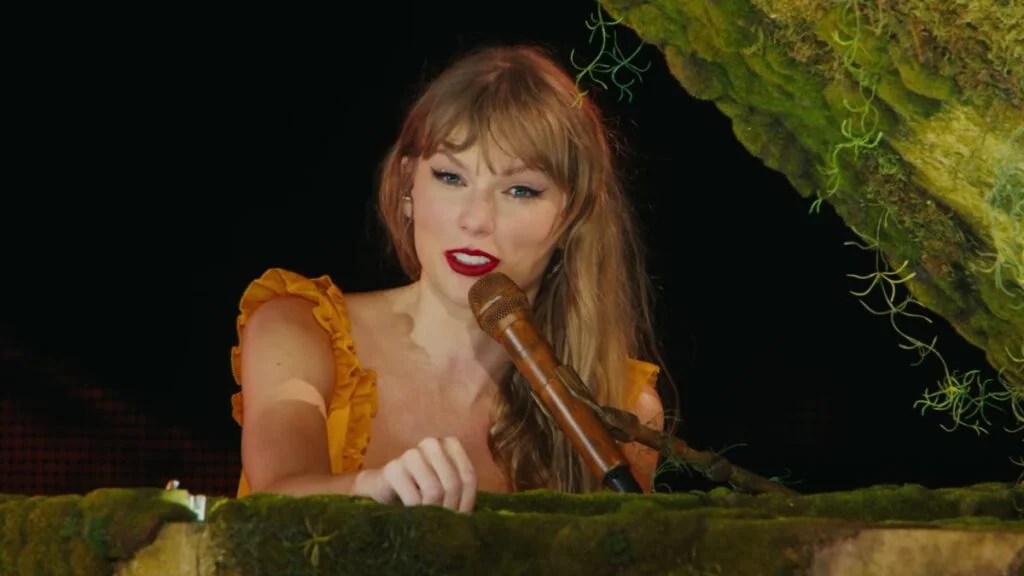 Taylor Swift parle avant de jouer "Champagne Problems" dans "Taylor Swift : The Eras Tour" (Crédit : AMC)