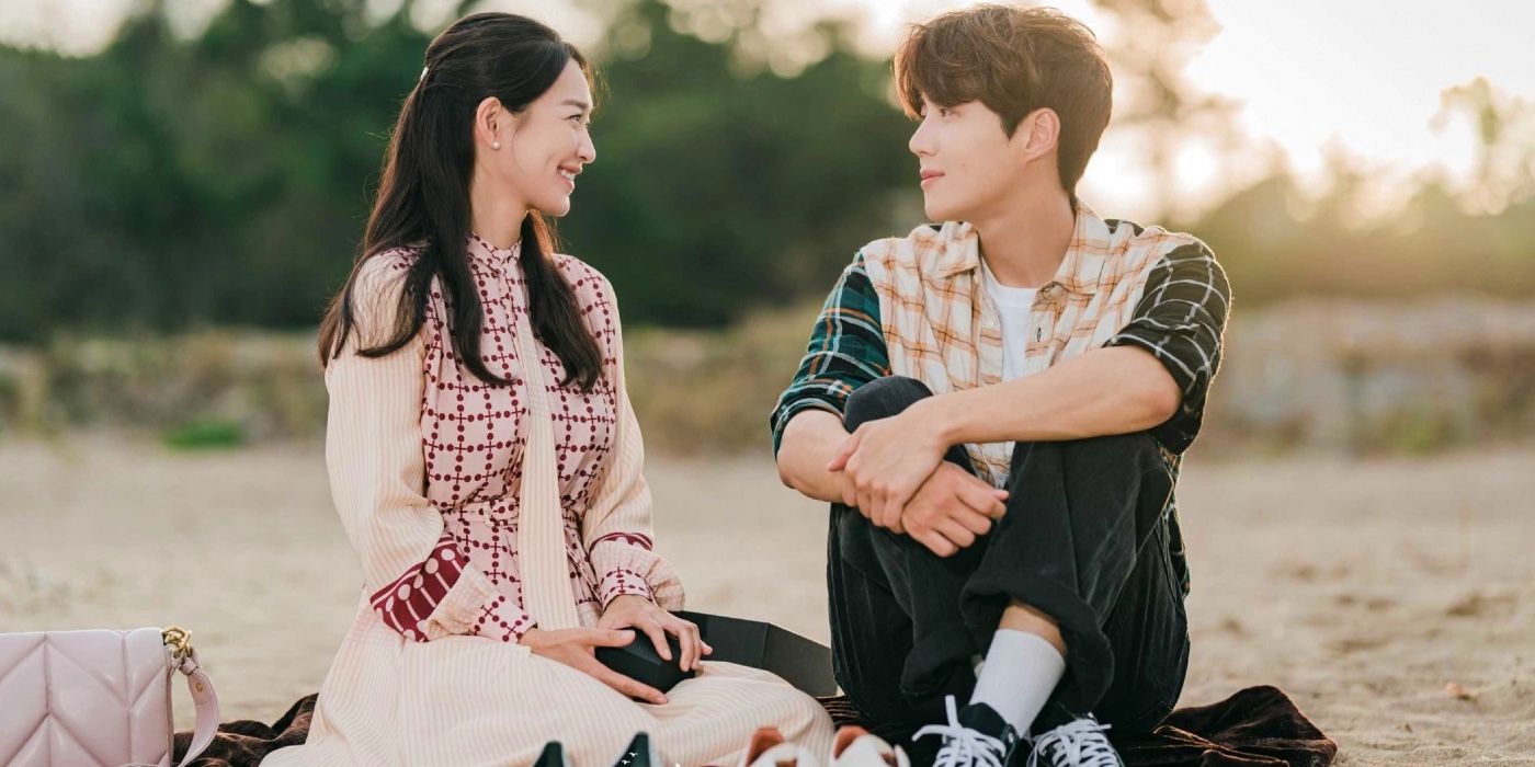 Two characters sitting on a beach and smiling at one another in Hometown Cha-Cha-Cha