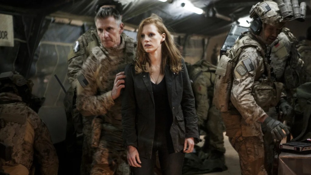 Stationnée dans une base secrète à l'étranger, Maya (Jessica Chastain) fait partie de l'équipe d'élite d'espions et d'agents militaires (Christopher Stanley, à gauche, et Alex Corbet Burcher, à droite) qui se consacrent à la recherche d'Oussama ben Laden (Crédit : Universal Pictures)