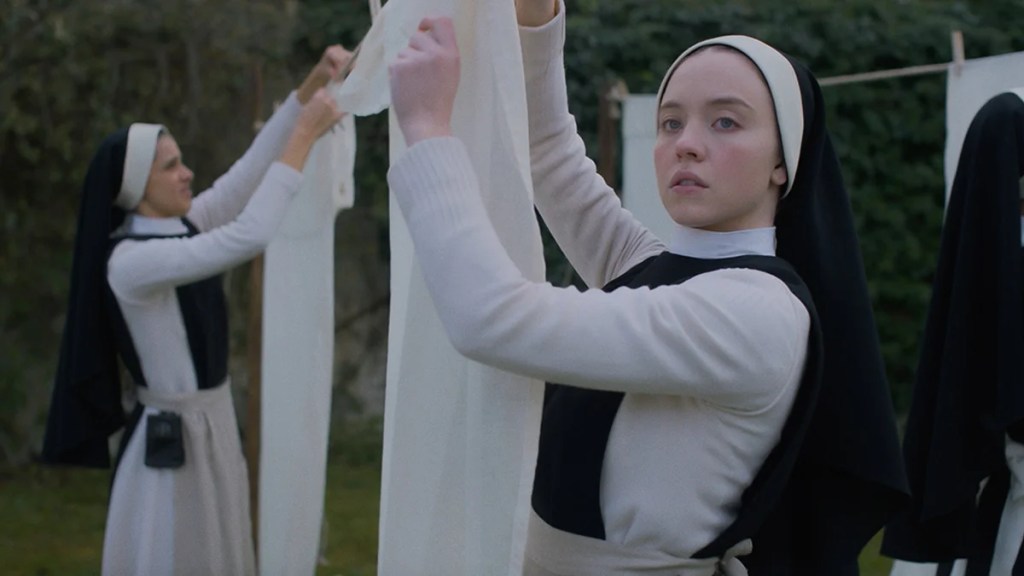 Sydney Sweeney, une femme à la peau claire, habillée en nonne avec d'autres nonnes en arrière-plan dans « Immaculée ».