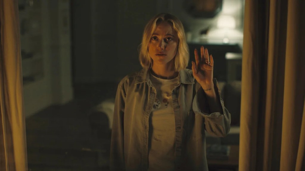 Maika Monroe presse sa main contre une fenêtre de "Watcher".