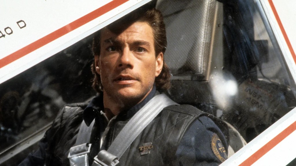 Jean-Claude Van Damme est assis dans un navire blanc.