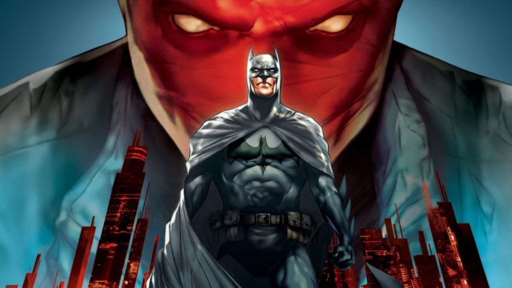 Batman se tient devant une ville avec un homme dans un masque rouge qui se profile en arrière-plan