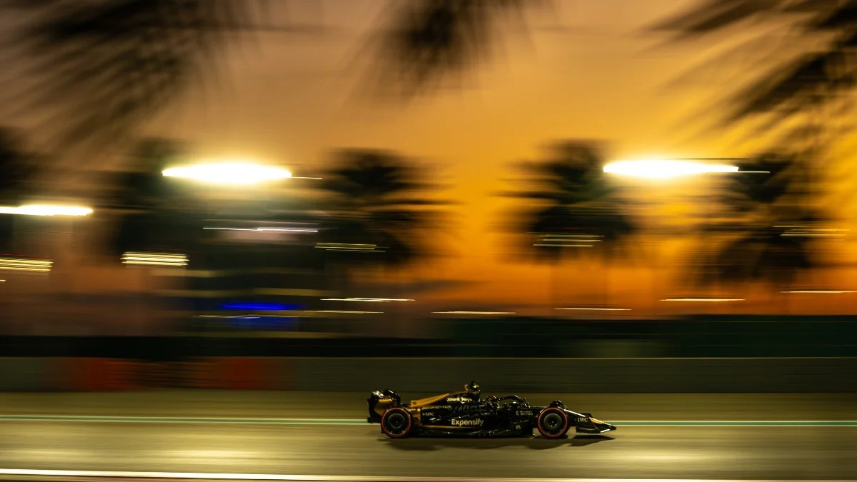 A Formula One car races at sunset in