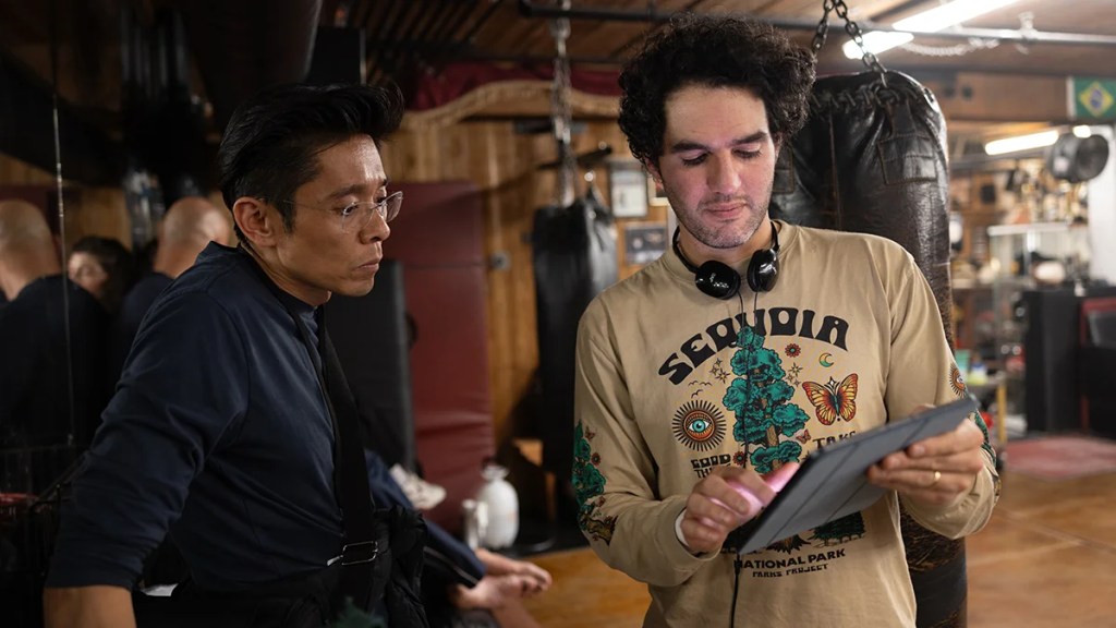 Kazu Hiro et Benny Safdie regardent une tablette sur le tournage de "The Smashing Machine"