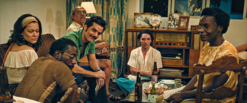 Une image fixe de "L'agent secret" d'Armando (Wagner Moura) et d'autres réfugiés politiques au refuge de Dona Sebastiana (Tânia Maria).