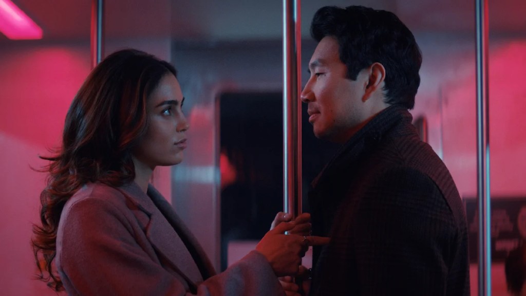 Melissa Barrera (à gauche) et Simu Liu (à droite) se tiennent sous un éclairage rouge dans "The Copenhagen Test"