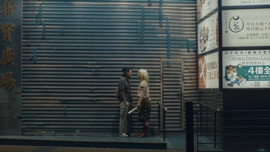 Jin Ha et Haley Lu parlent ensemble de quelque chose d'urgent dans les rues de Hong Kong dans une photo de Kogonada's Zi.
