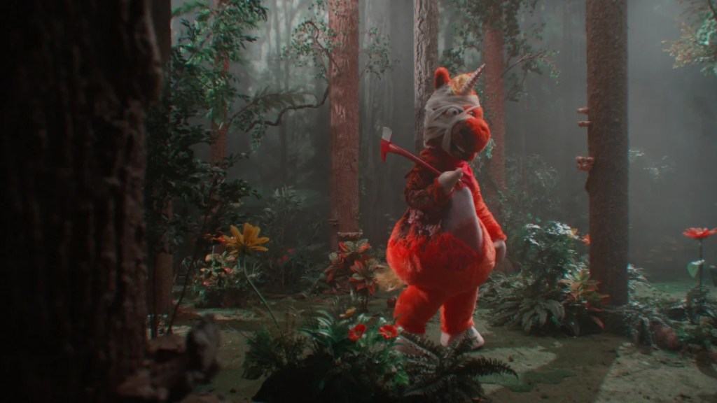 Un costume de mascotte en uniforme orange est bandé et ensanglanté dans les bois avec une hache