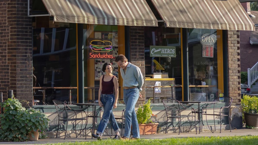 Jenny Slate et Chris Pine marchant ensemble devant une sandwicherie dans "Carousel".
